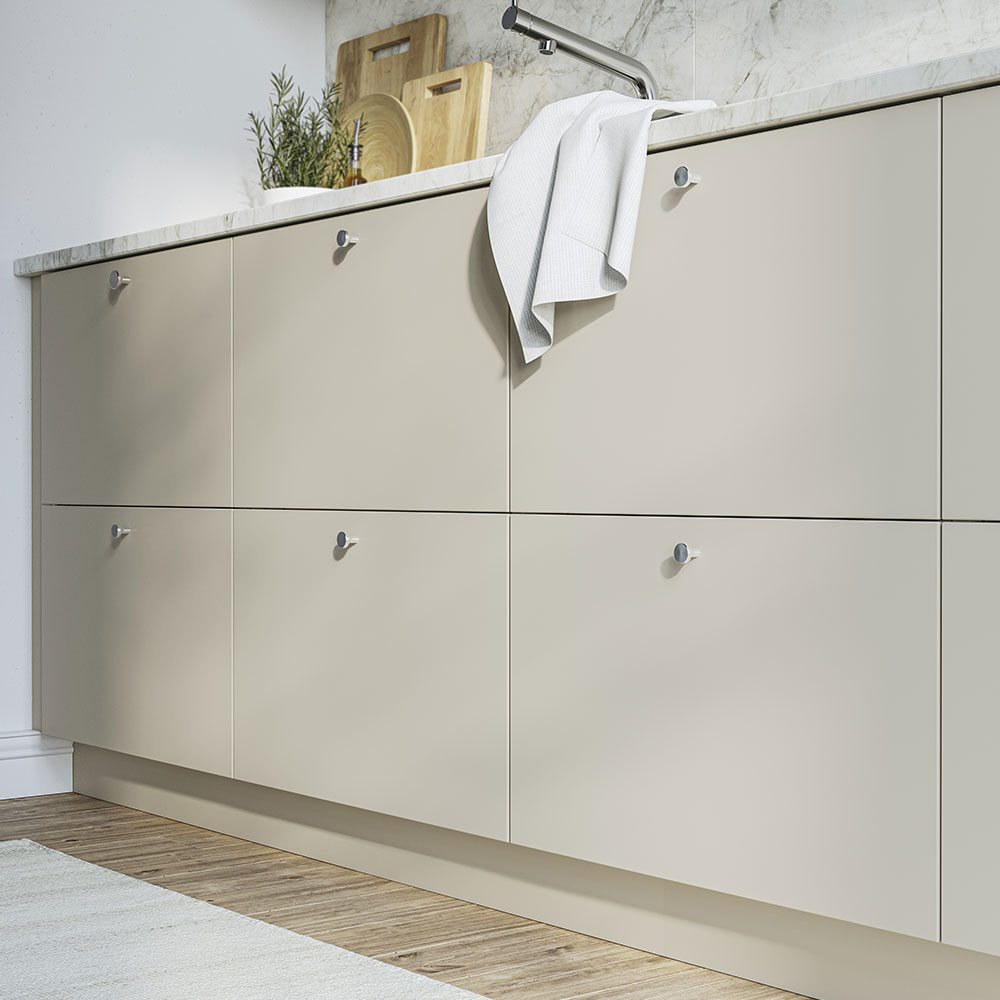 Low-angle view of a kitchen with matte beige lower cabinets, countertop, and faucet.