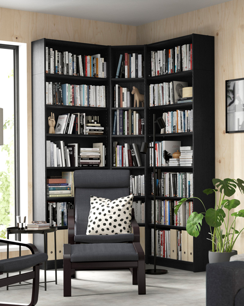 A BILLY bookcase black next to POÄNG armchair black