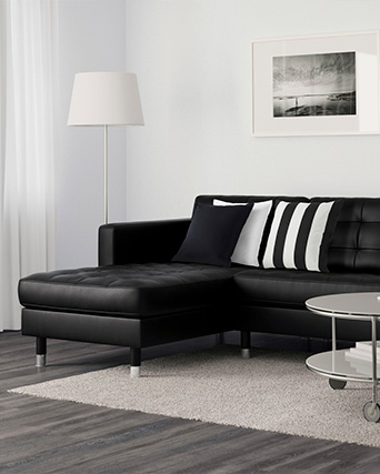 Una sala de estar con un sofá LANDSKRONA de 3 plazas, una alfombra KNARDRUP y una lámpara de piso NYFORS.