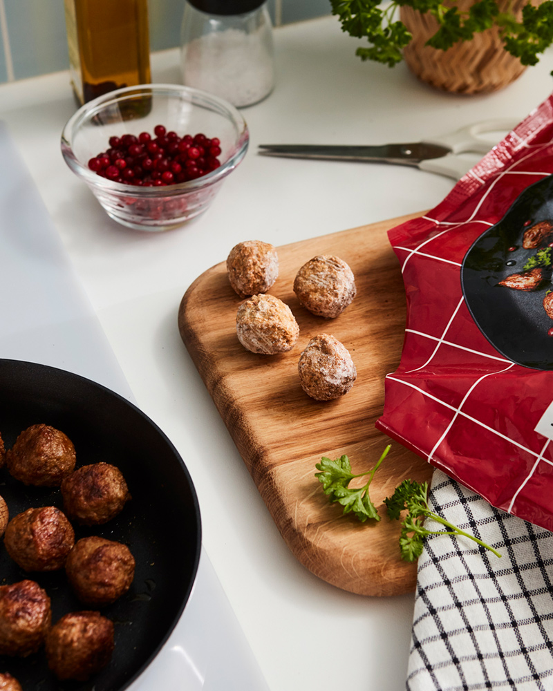IKEA Swedish meatballs on a skillet and a wooden board.