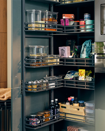 Interior de un armario de cocina con estantes y soluciones extraíbles UTRUSTA, organizando alimentos y botellas. Maximiza el espacio de tu despensa.