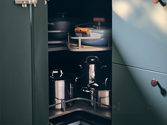 Interior de un armario de esquina de cocina oscuro con estantes extraíbles, organizando ollas y sartenes. Soluciones inteligentes para optimizar cada rincón.