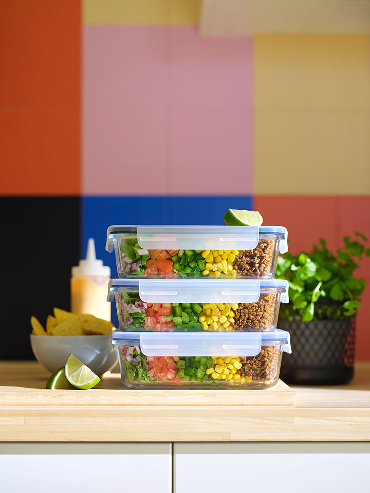 Three IKEA 365+ food containers with lid on top of each other, containing food, and an IKEA 365+ bowl holding potato chips