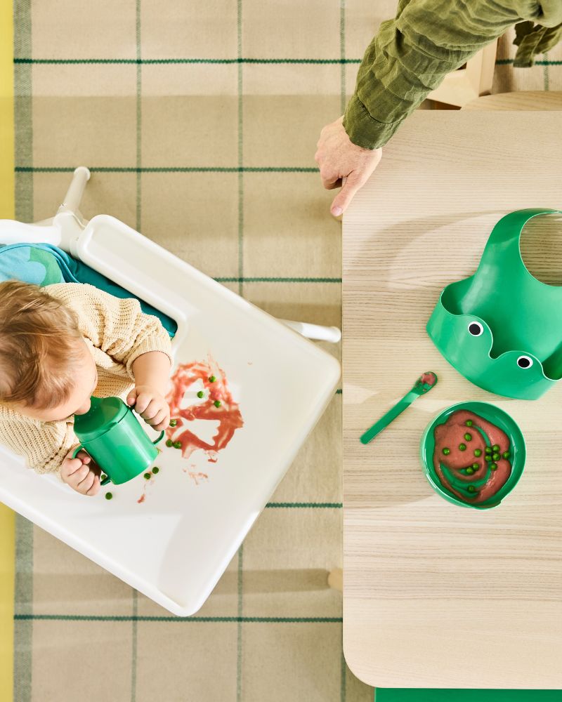 Bright green frog-themed four piece MATA baby tableware set with bib, bowl, sippy cup and spoon.