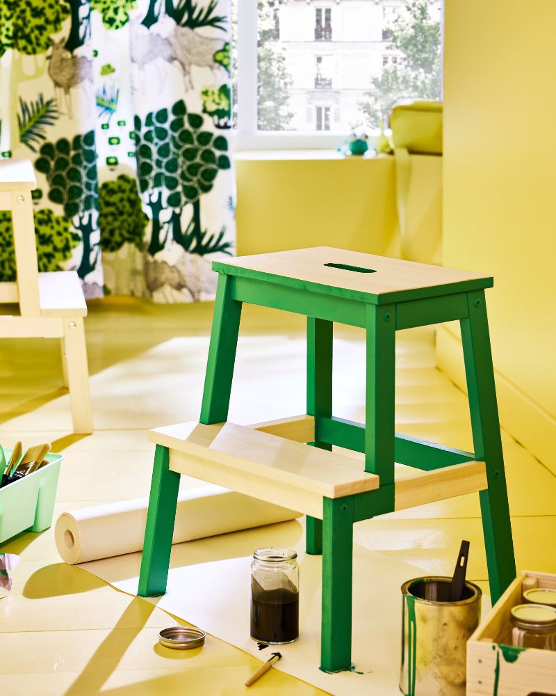 Wooden BEKVÄM step stool painted to look like a green frog in a modern kitchen.