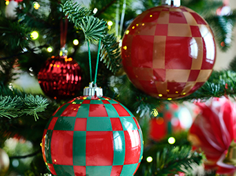 Plano cerrado de bolas rojas, y verdes decorando un árbol