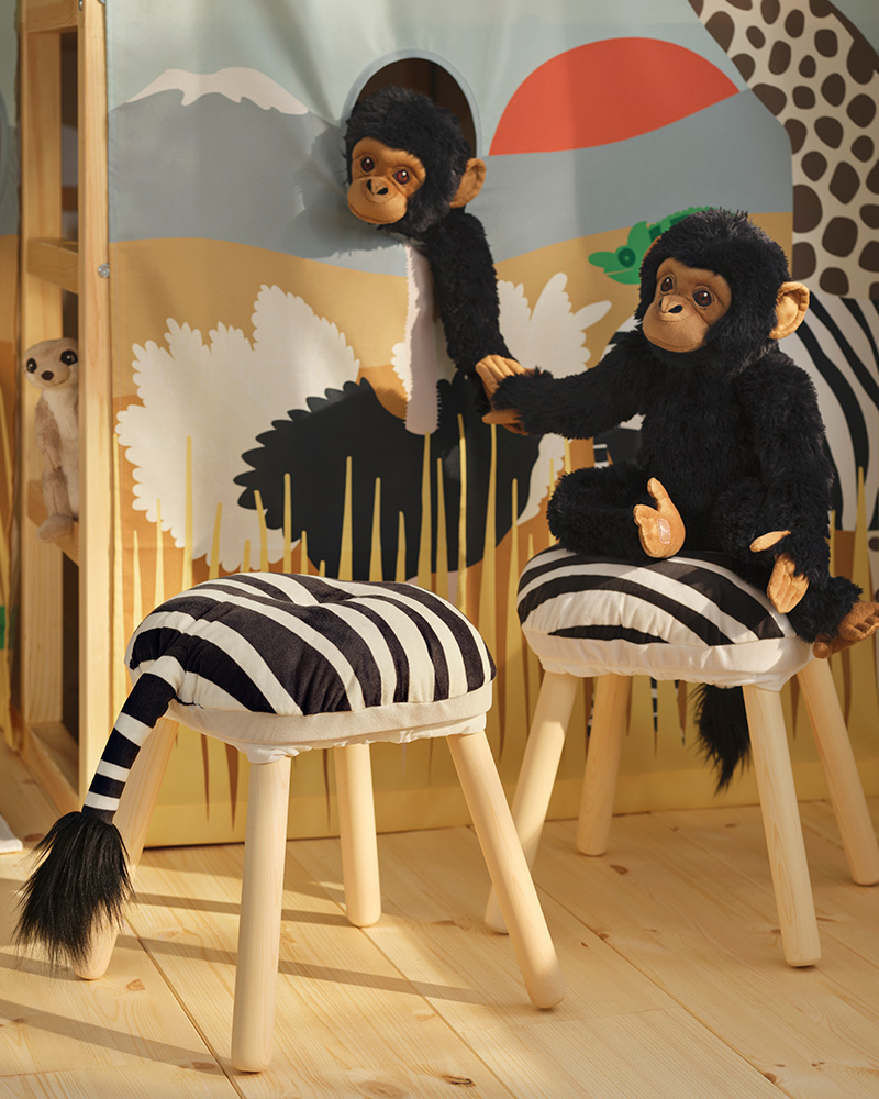 Two black SANDLÖPARE soft toy chimpanzees hold hands in a bright savannah themed children’s room