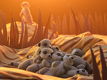 Un grupo de suricatas de peluche de la colección SANDLÖPARE duerme amontonado sobre una sabana iluminada por el sol, hecha con recortes de cartón y ropa de cama.