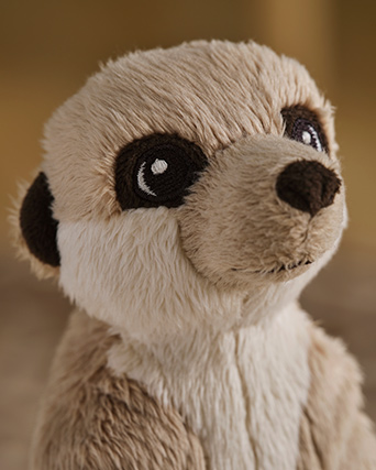 Una suricata de peluche beige de la colección SANDLÖPARE, con ojos grandes, está sentada erguida, mostrando su suave pelaje y su expresión encantadora.