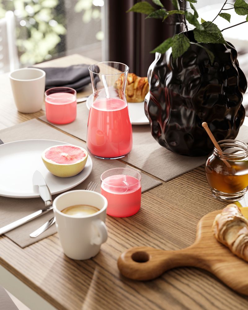 A brunch table setting for two, with coffee, juice, fresh fruit and croissants, is placed on an ÅLHULT extendable table.