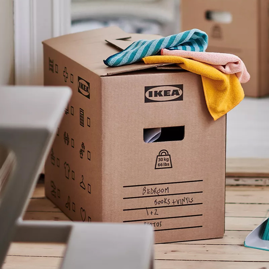 Cardboard moving box with folded textiles on top, ready for packing and organizing.