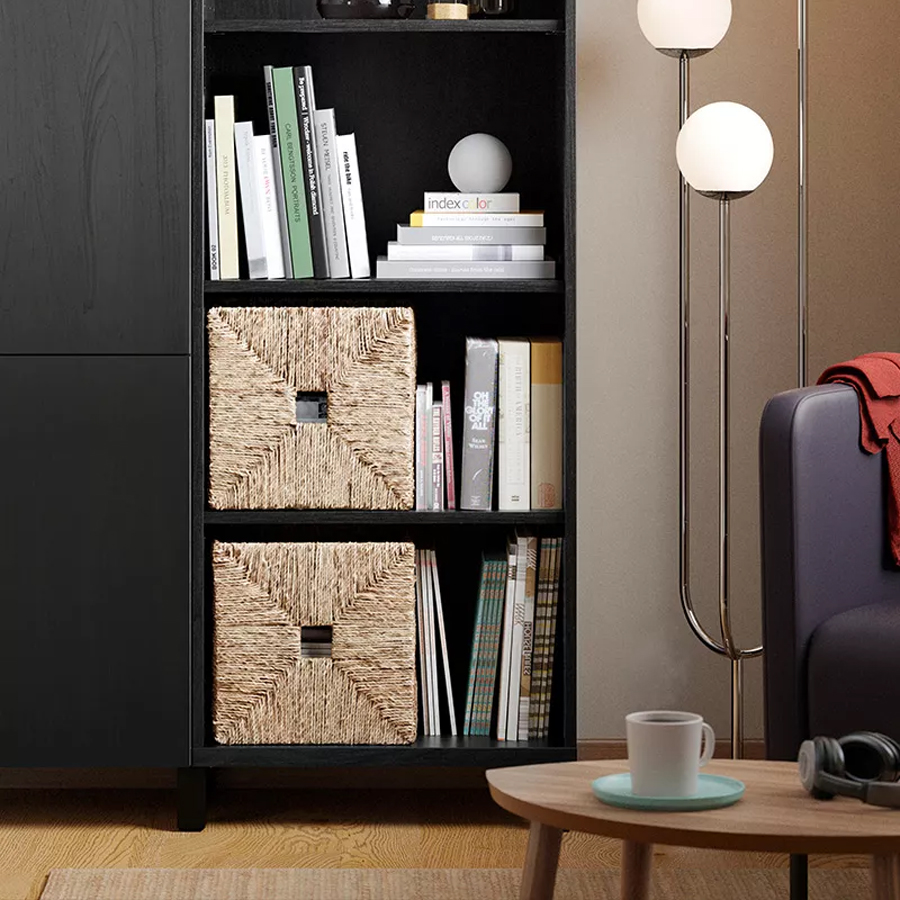 Black bookcase with books, woven storage boxes, and a floor lamp in a cozy living room.