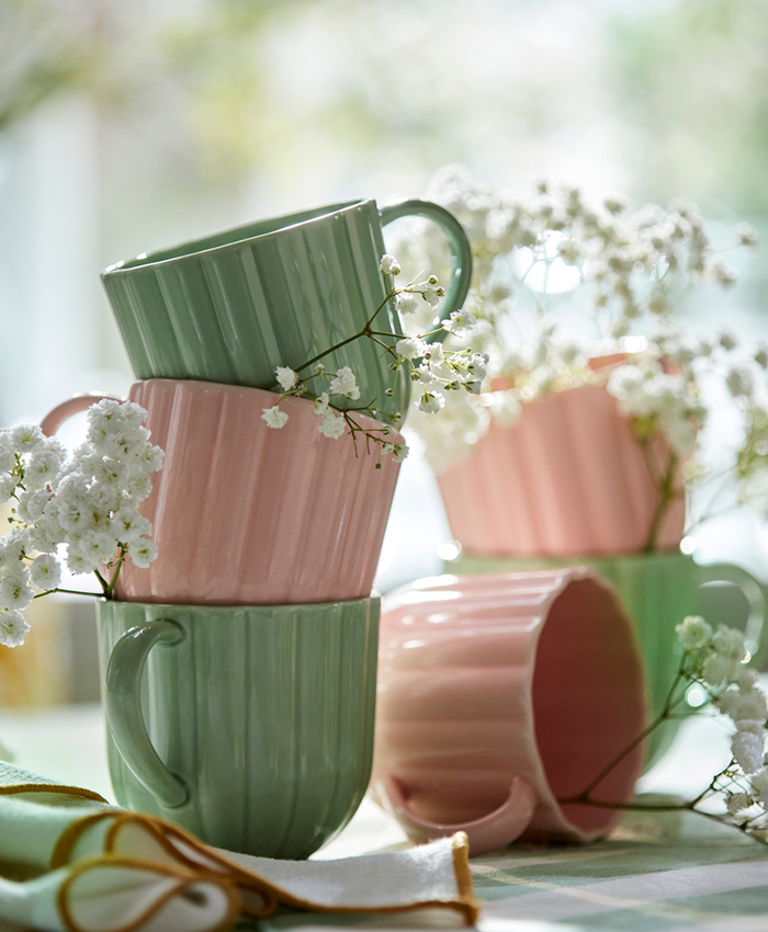 Green and pink cups arranged decoratively, with white flowers inside