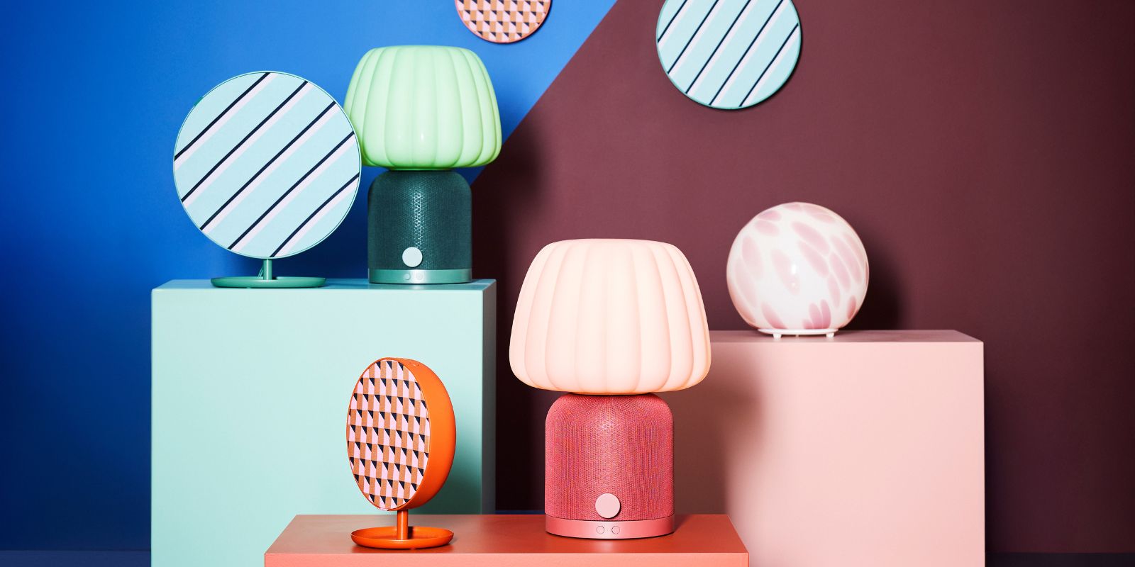 A playful pedestal arrangement of KULGLASS and SOLSKYDD Bluetooth speaker lamps and speakers, along with a FADO lamp