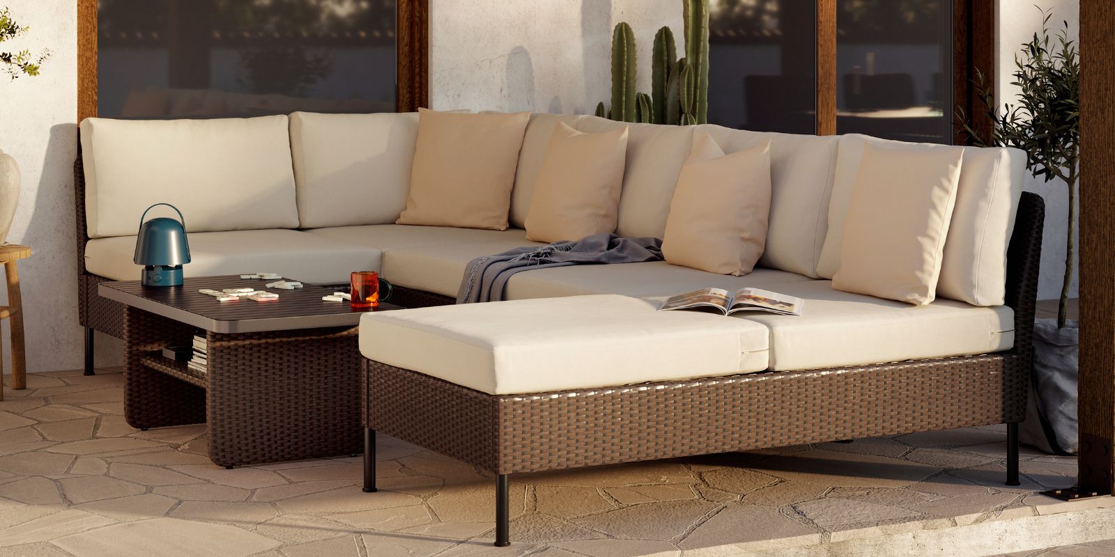 A generous outdoor lounge area with VITTSKÄR modular sofas and coffee table in dark grey. A large plant pot next to it.