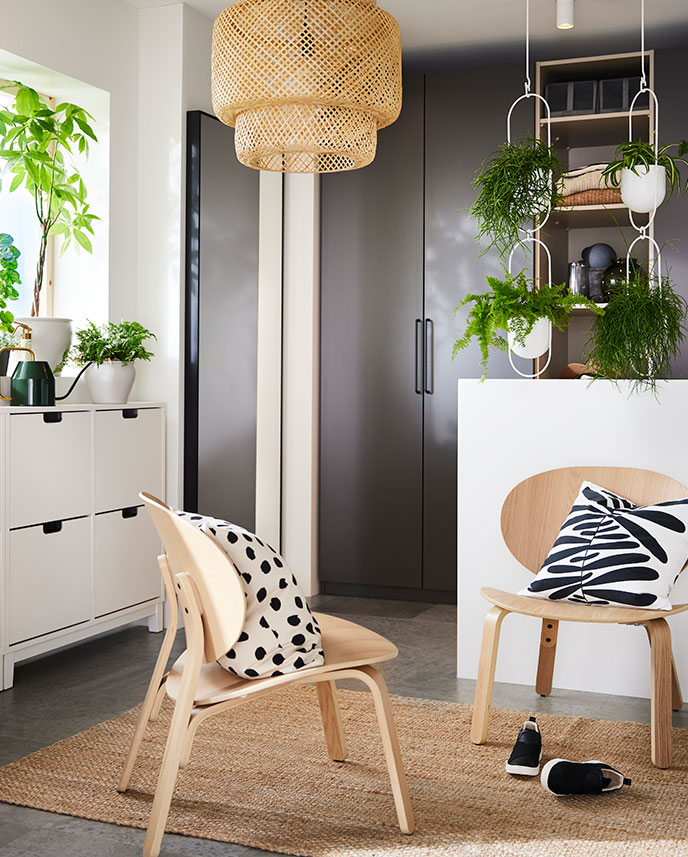 On a LOHALS rug are two FRÖSET chairs with MAJSMOTT cushions. In the background are dark-gray PAX wardrobes.