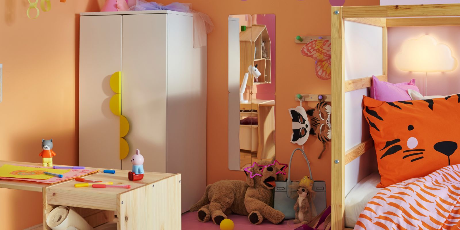 A light white stained pine TROFAST frame and tabletop make a desk in a child’s bedroom with a SMÅSTAD/PLATSA wardrobe