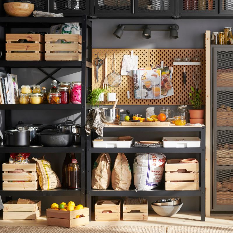 Organized pantry with IVAR and BROR shelves, KNAGGLIG boxes, SORTERA bins and a SKÅDIS board for a warm, functional space.