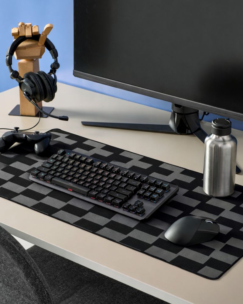 Gaming desk scene with BLÅSKATA mouse pad and LÅNESPELARE accessory stand, arranged in a clean and organized setup.