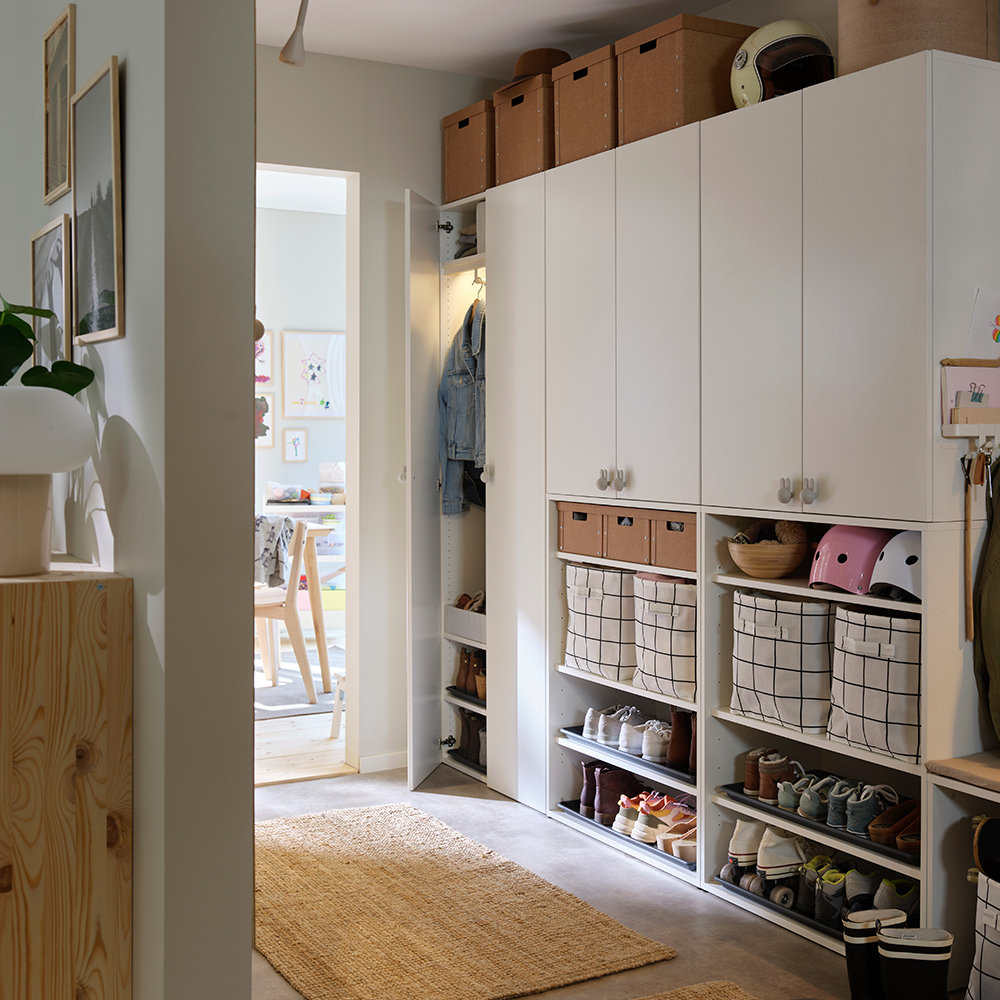 LASTARE wardrobe combinations with closed cabinets, baskets, helmets and shoe storage arranged neatly in a hallway.