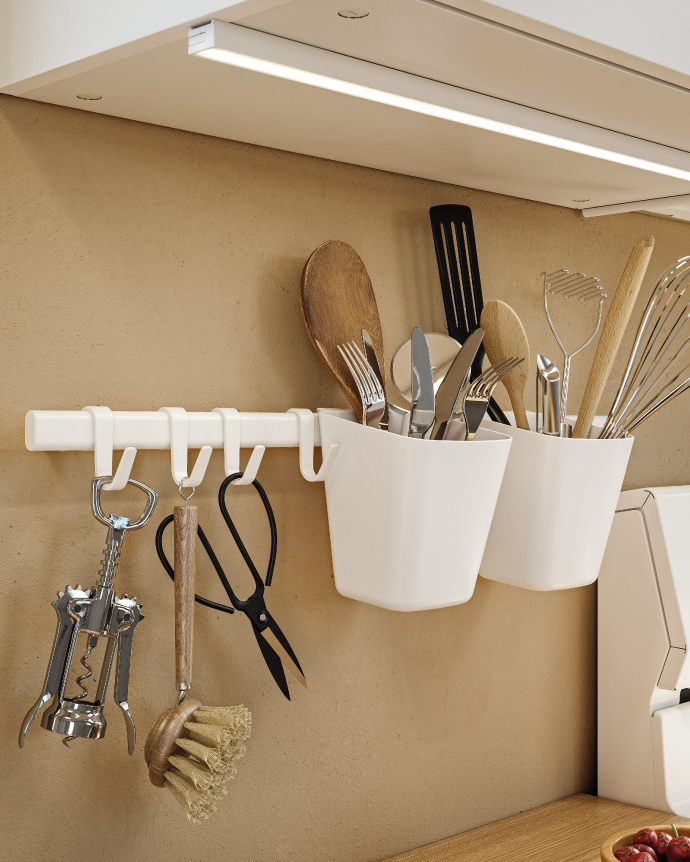 White wall rail with hooks and bins organizing kitchen utensils under an LED light strip.