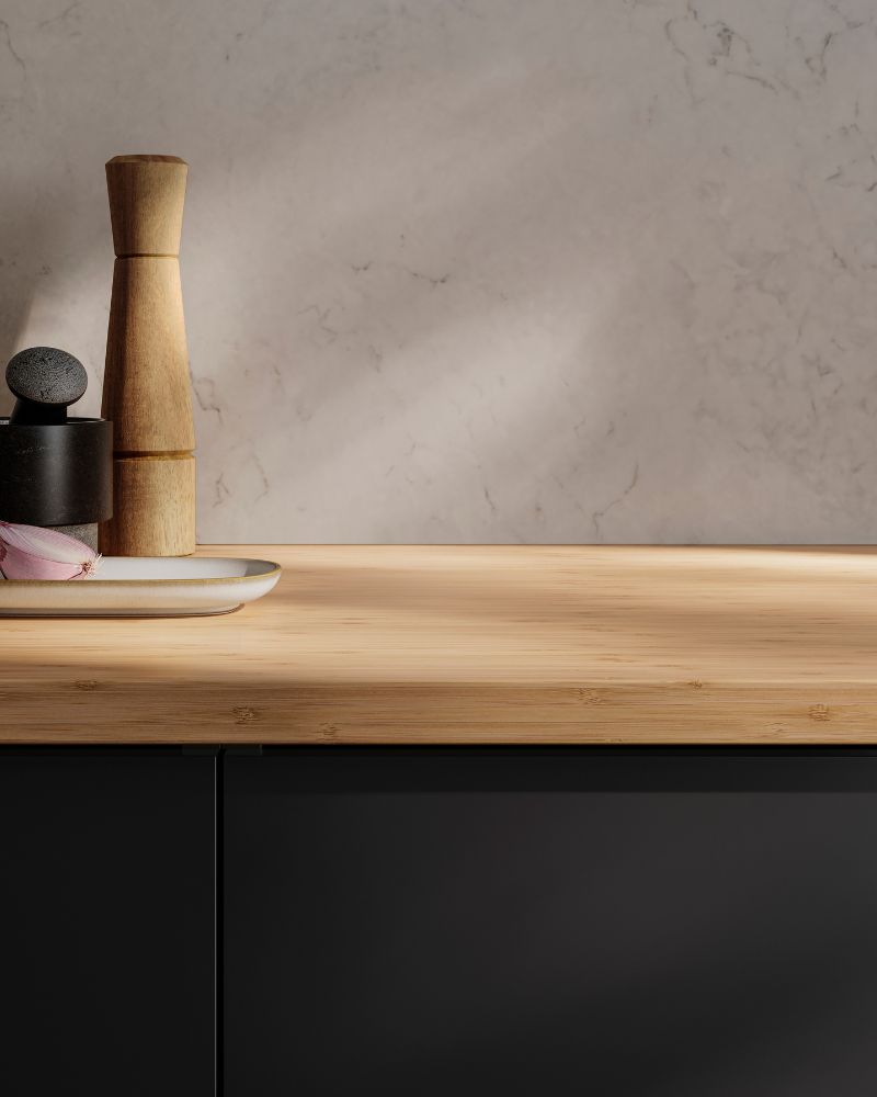 Warm kitchen countertop scene with IKEA HOLMARED countertop, INTRESSANT spice mills, ÄDELSTEN mortar and GLADELIG plate.