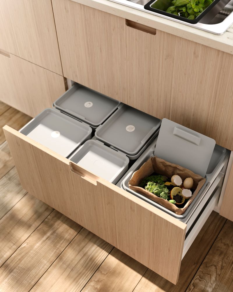 Warm kitchen recycling setup with FRÖJERED drawer fronts and HÅLLBAR containers neatly sorted inside a pull-out drawer.