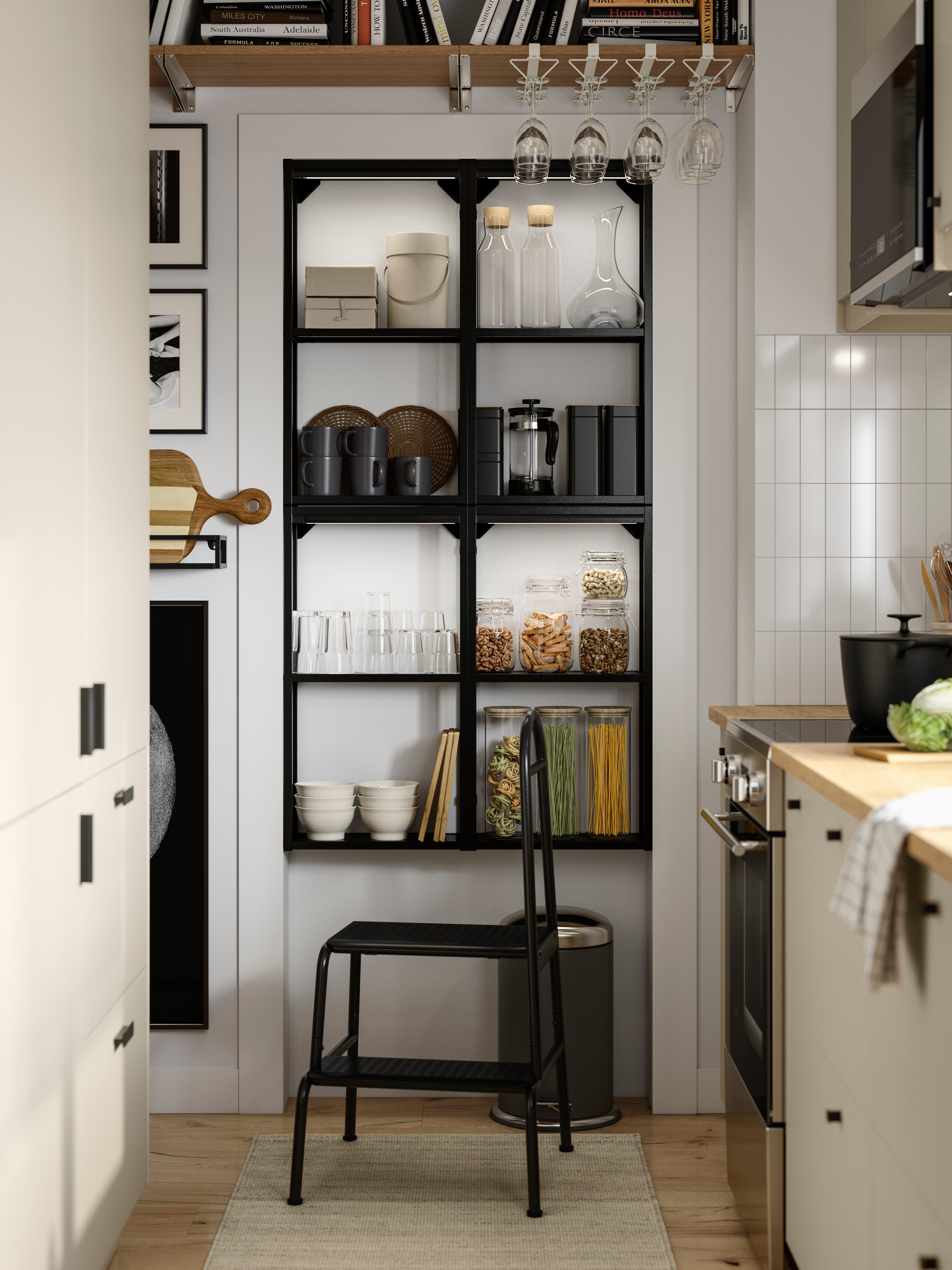 Estantería abierta negra en la cocina con frascos de alimentos, vasos y utensilios organizados.