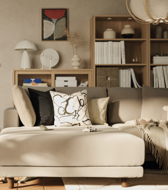 Sofá cama amarillo con cojines blanco y negro junto a una ventana con cortinas claras.