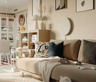 Sala moderna con sofá beige, cojines decorativos, manta clara y estantería organizada al fondo.