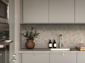 Cocina minimalista con gabinetes grises, salpicadero texturizado, fregadero integrado y decoración con plantas y botellas.