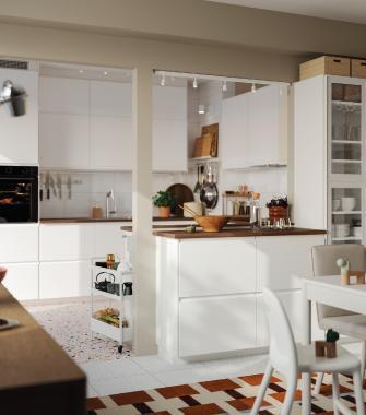 Cocina abierta con isla central blanca, gabinetes modernos, área de comedor y diseño espacioso y luminoso.