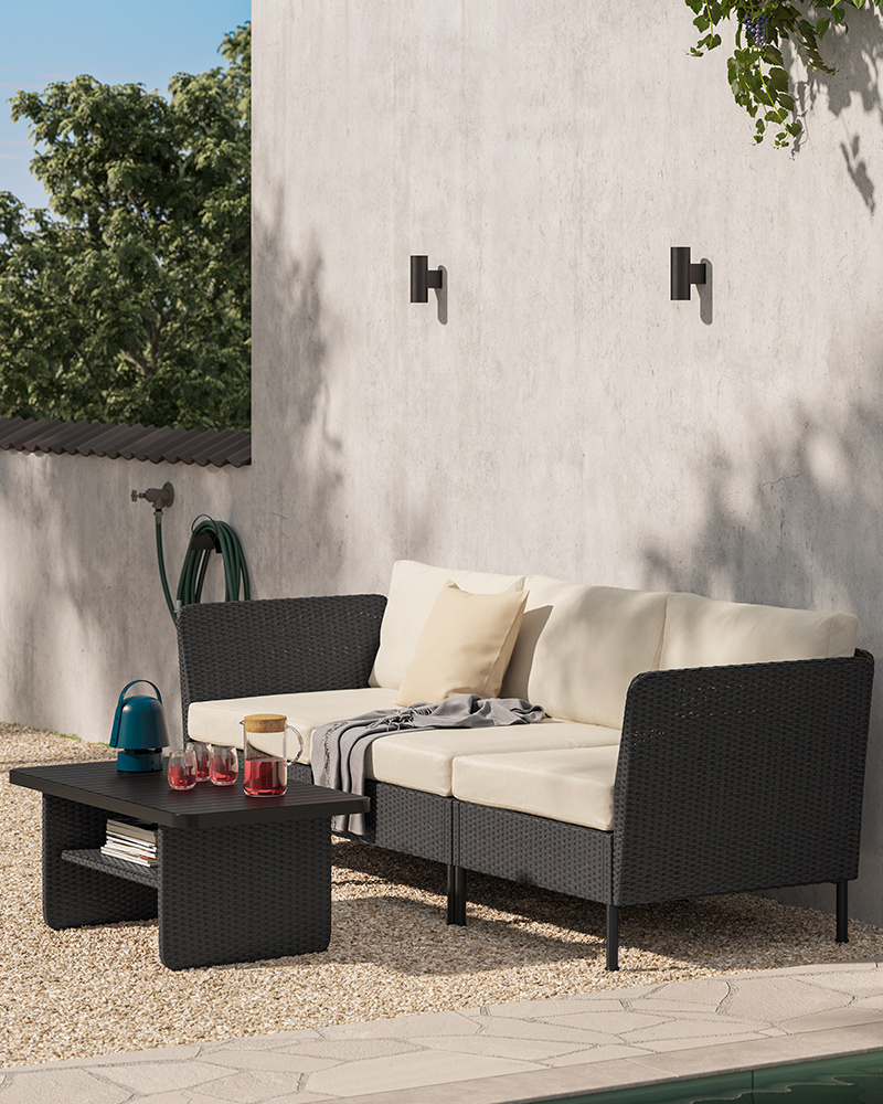 Outdoor VITTSKÄR three-seater furniture with a HEDSÄV cushion and an HOLMVI blanket, along with a GRÖNSPRÖT wall lamp.