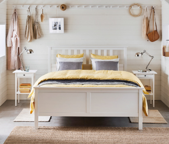 Dormitorio minimalista con cama blanca y ropa amarilla
