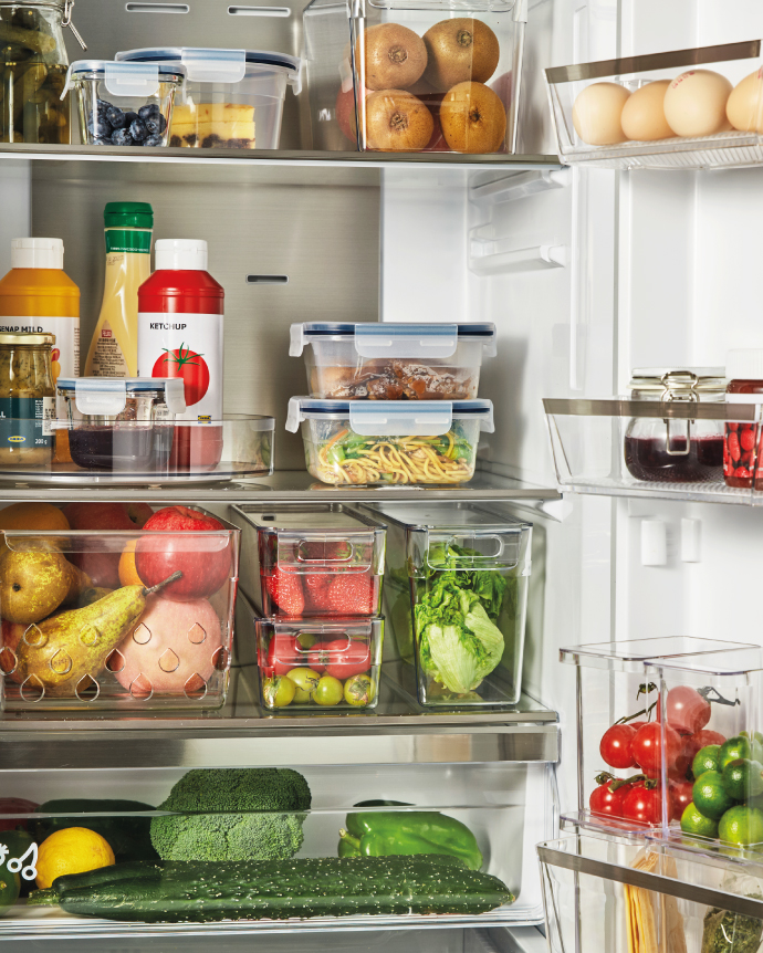 Organized refrigerator interior with fruits, vegetables, and containers.