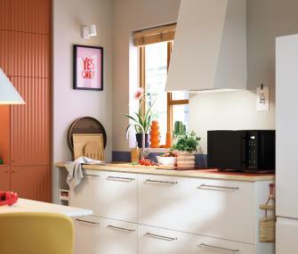 Cocina moderna blanca con encimera de madera y decoración natural.