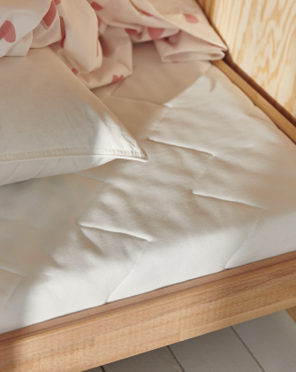 Cama de madera con colchón blanco acolchado y almohada.