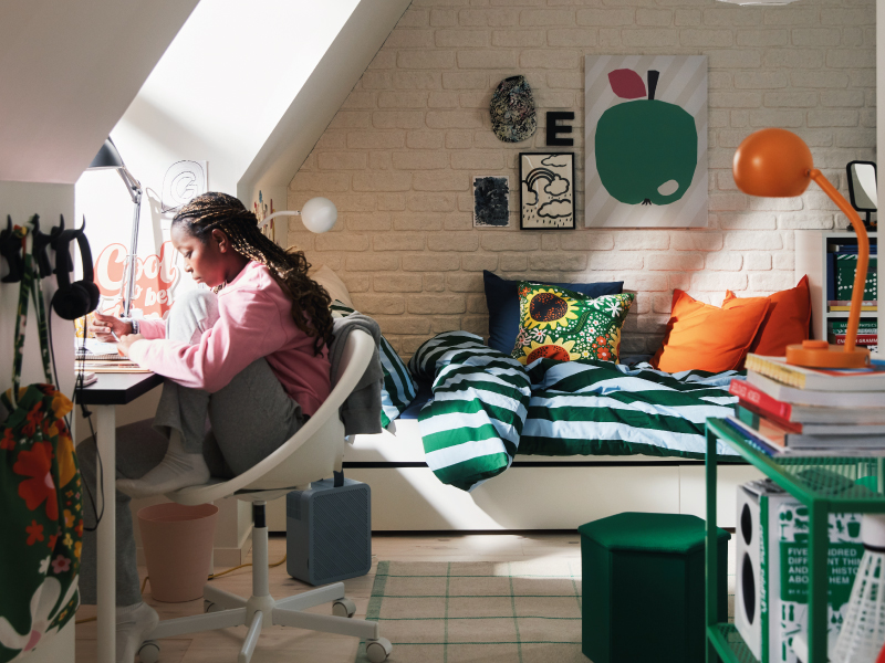 Youth room with a study desk and neatly made bed.