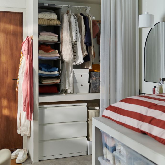 Organized wardrobe with SLÅNHÖSTMAL duvet cover set, STORKLINTA chest of drawers, SKUBB storage and LINDBYN mirror.