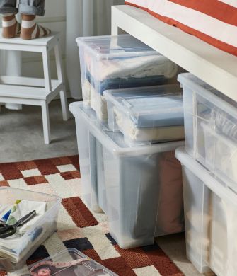 Practical storage area with SAMLA boxes, MARKBLÅMME rug, SLÅNHÖSTMAL duvet cover set and BEKVÄM step stool.