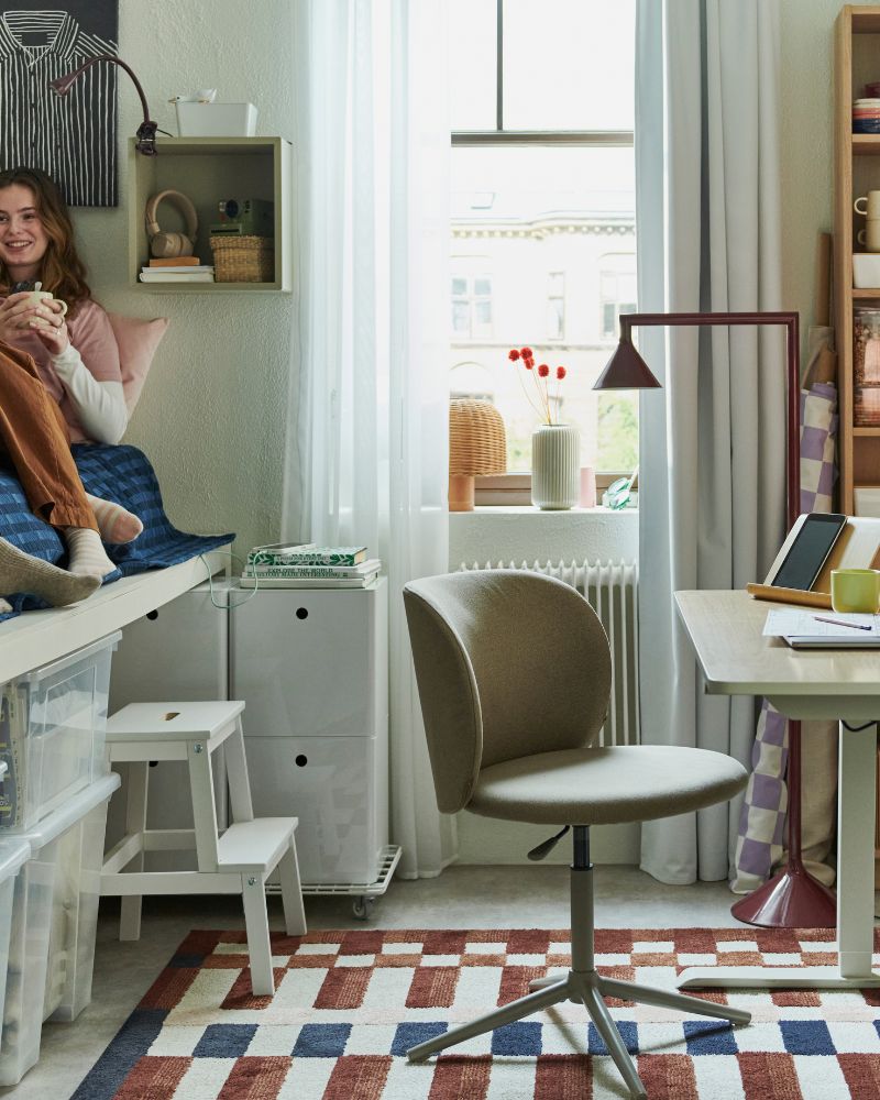 Functional bedroom with TRAVSPORT sit/stand desk, KRYLBO swivel chair, MARKBLÅMME rug, BILLY bookcase and IKEA PS 2026 lamp.