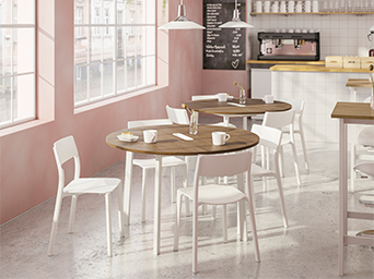 Bright coffee shop interior with round wooden tables, white chairs, and pink walls.