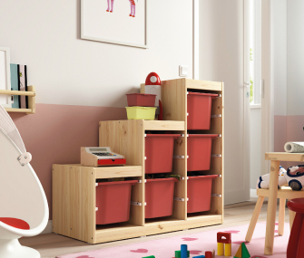 Organizador infantil de madera con cajas rojas en una sala de juegos.