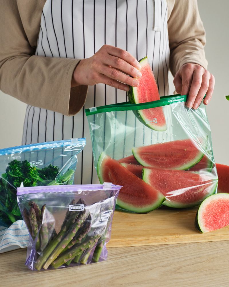 Practical kitchen with APTITLIG cutting board and ISTAD resealable bags for storing fruits and vegetables.