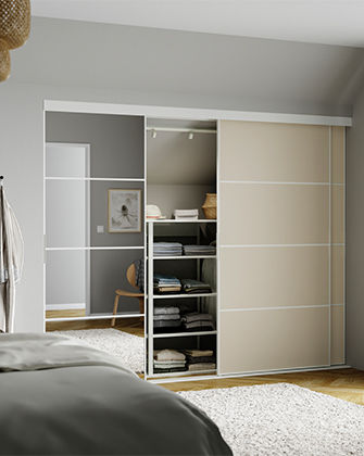 Armario empotrado con puertas correderas de espejo y paneles beige que muestran ropa doblada.