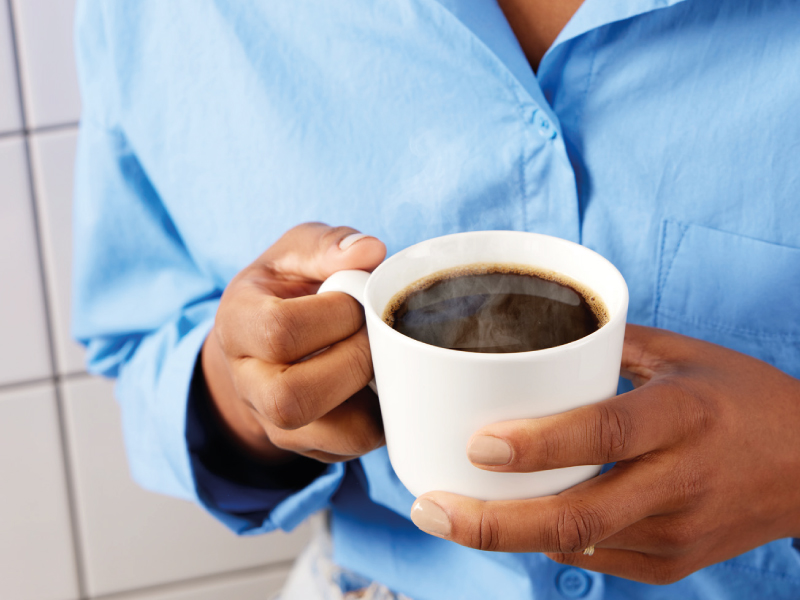 Person holding a cup of hot coffee.