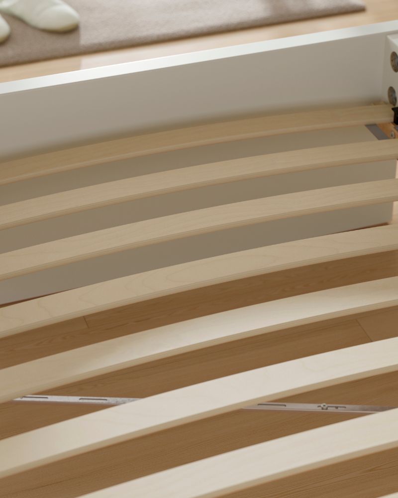 Minimalist bedroom detail with LURÖY slatted bed base, featuring curved wooden slats for mattress support.